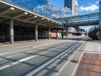 empty street with pedestrian walkway and modern buildings in background in urban area, outdoors in daytime