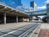 empty street with pedestrian walkway and modern buildings in background in urban area, outdoors in daytime