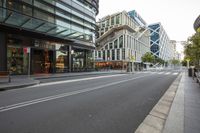 a street is empty with a few buildings next to it as well as an empty road