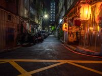 a night shot showing a street that is empty with motorcycle parked in it and a building in the background