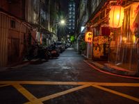 a night shot showing a street that is empty with motorcycle parked in it and a building in the background