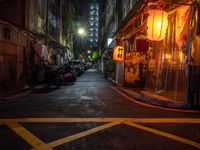 a night shot showing a street that is empty with motorcycle parked in it and a building in the background