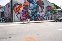 an empty street that has several paintings and graffiti on it on the sidewalk of a city street