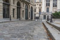 an empty street in front of a building that is called art nouveau paris it has a brick sidewalk and a lamp post