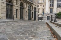 an empty street in front of a building that is called art nouveau paris it has a brick sidewalk and a lamp post