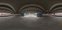 the street is empty in the parking garages near the buildings, a blue truck with a yellow stripe drives away