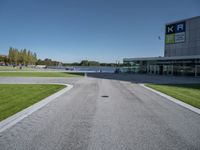 an empty street and parking lot with the sky in the background behind it, as people walk by