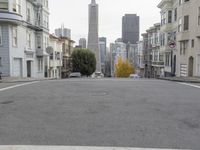 an empty street in front of tall buildings and skyscrapers in the background as seen from near the edge of the road