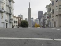 an empty street in front of tall buildings and skyscrapers in the background as seen from near the edge of the road