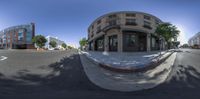 a 360 - camera lens view of an empty street in front of a large brick building