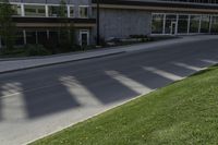 a road with an empty street sign on the sidewalk in front of a building with multiple windows