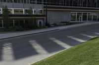 a road with an empty street sign on the sidewalk in front of a building with multiple windows