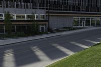 a road with an empty street sign on the sidewalk in front of a building with multiple windows