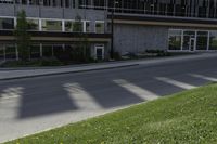 a road with an empty street sign on the sidewalk in front of a building with multiple windows