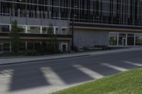 a road with an empty street sign on the sidewalk in front of a building with multiple windows