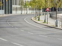 empty street with multiple signs on the side of the road in front of tall buildings