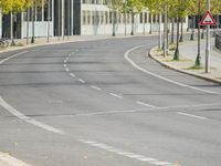 empty street with multiple signs on the side of the road in front of tall buildings