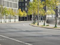 empty street with multiple signs on the side of the road in front of tall buildings