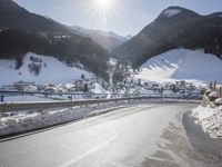 an empty street is shown with no cars on it in the middle of the snowy mountain