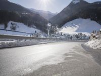 an empty street is shown with no cars on it in the middle of the snowy mountain