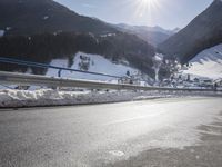 an empty street is shown with no cars on it in the middle of the snowy mountain