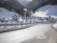 an empty street is shown with no cars on it in the middle of the snowy mountain