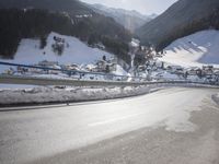 an empty street is shown with no cars on it in the middle of the snowy mountain