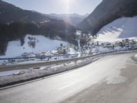 an empty street is shown with no cars on it in the middle of the snowy mountain