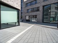 a empty street and window on a sunny day in the city area of the business district