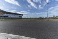 an empty street with the stadium in the distance and sky behind it from a wide angle