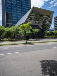 an empty street in a city with buildings and trees behind it with a water puddle