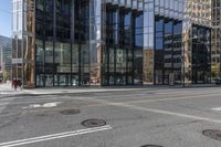 an empty street is next to a tall building that is connected by a road that goes up into the other side