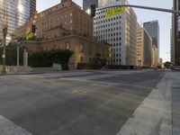 an empty city street with tall buildings and cars parked in the middle of the road