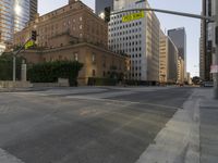 an empty city street with tall buildings and cars parked in the middle of the road