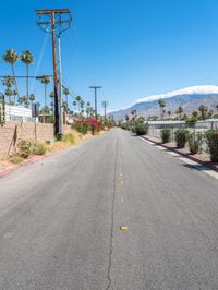 empty street lined with telephone poles and a mountains in the distance in palm springs, california