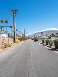 empty street lined with telephone poles and a mountains in the distance in palm springs, california