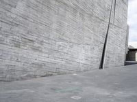 a skateboarding riding a skateboard next to some walls and stairs in an empty city street