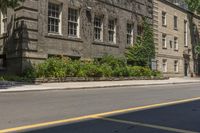 an empty street next to buildings with plants and flowers in the corner of the road