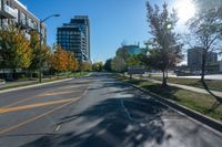 a empty street is shown with buildings and some trees in the background during autumn time