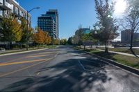 a empty street is shown with buildings and some trees in the background during autumn time