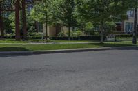 a stop sign is located in an empty street with trees and houses in the background