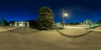 the street is empty and has the lights on and a street light above it,