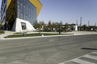 an empty street with no cars on it near a building that has some windows in the sides