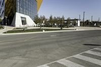 an empty street with no cars on it near a building that has some windows in the sides