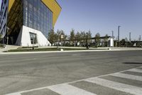 an empty street with no cars on it near a building that has some windows in the sides