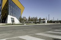 an empty street with no cars on it near a building that has some windows in the sides