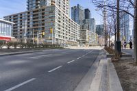 empty street with high rise building in background with pedestrians walking by in the foreground