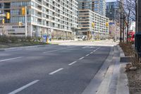 empty street with high rise building in background with pedestrians walking by in the foreground