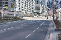 empty street with high rise building in background with pedestrians walking by in the foreground