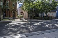 an empty street that leads to two old buildings on both sides and has a bench in front of the sidewalk